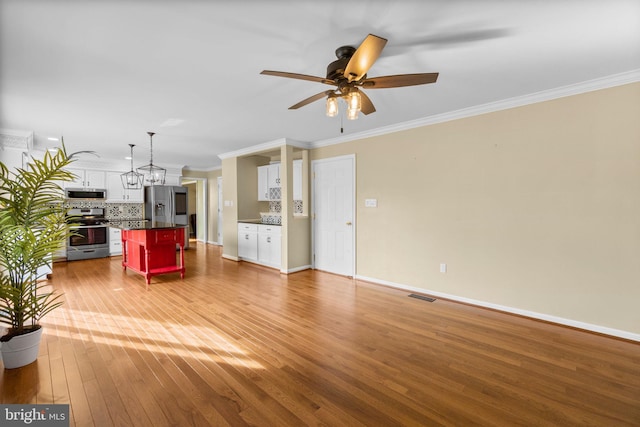 unfurnished living room with light wood-style flooring, crown molding, and baseboards