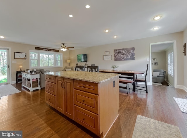 kitchen with dark wood-style floors, a kitchen island, and recessed lighting