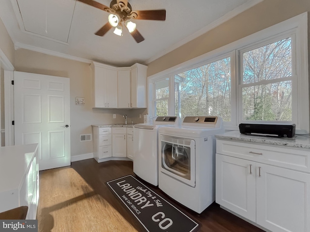 laundry area featuring dark wood-type flooring, a sink, visible vents, washing machine and clothes dryer, and attic access