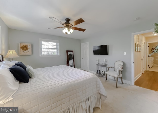 bedroom with a ceiling fan, light colored carpet, and baseboards