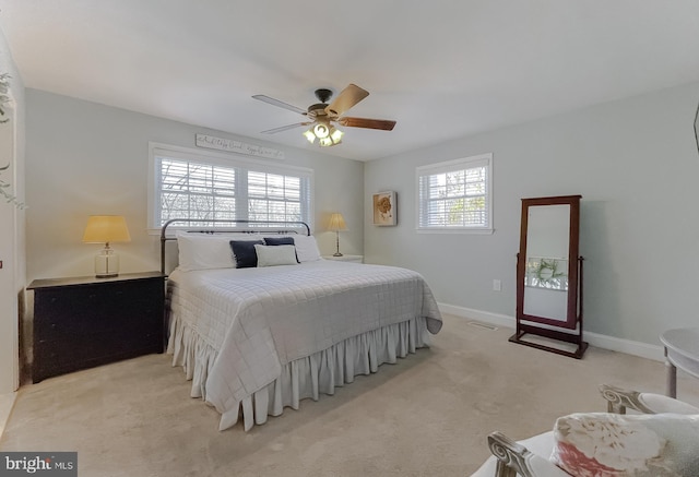 bedroom with light colored carpet, ceiling fan, and baseboards