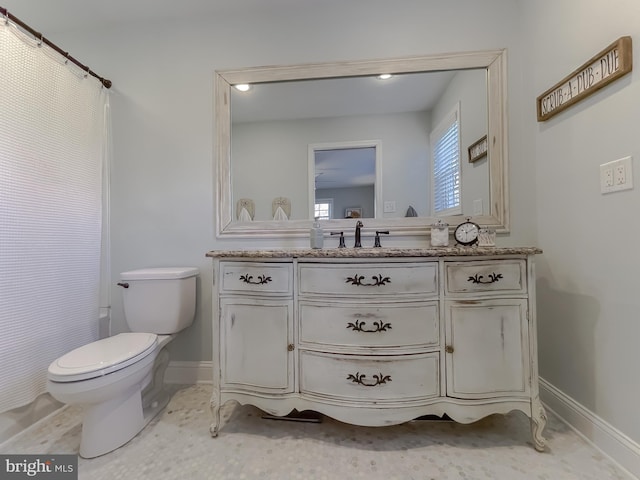 bathroom with curtained shower, baseboards, vanity, and toilet