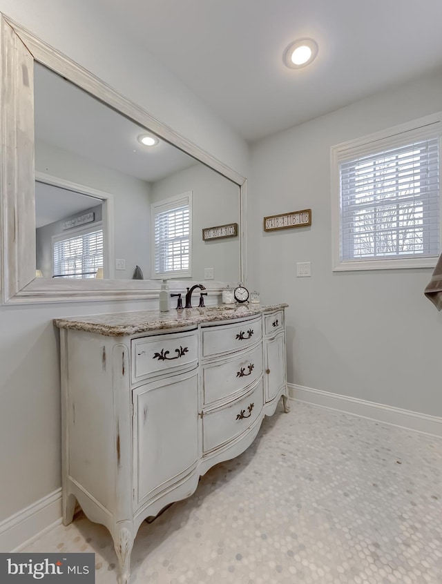 bathroom featuring baseboards, a sink, and recessed lighting