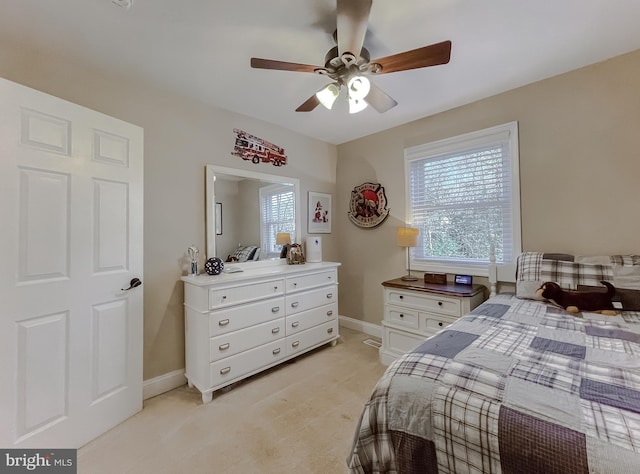 bedroom featuring a ceiling fan, light colored carpet, and baseboards