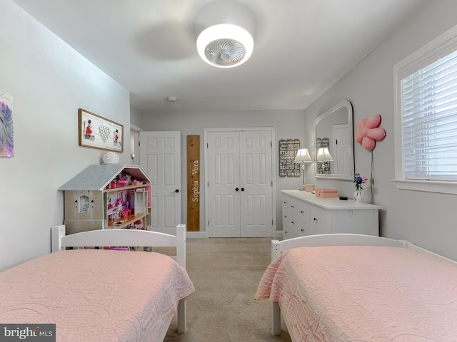 bedroom with ceiling fan, a closet, and light colored carpet