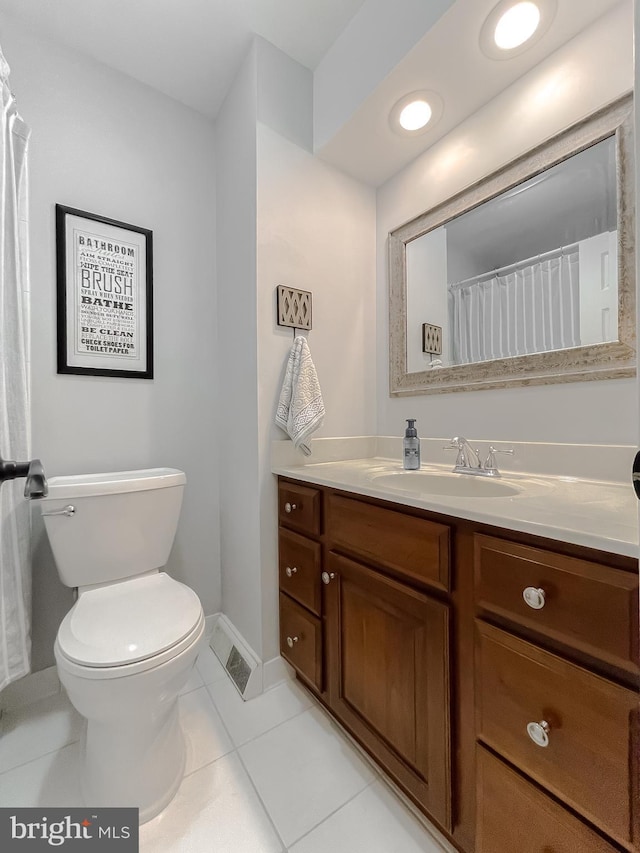 bathroom featuring visible vents, toilet, vanity, baseboards, and tile patterned floors