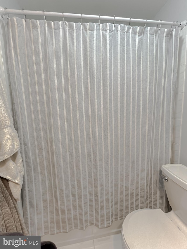 full bath with a shower with curtain and toilet