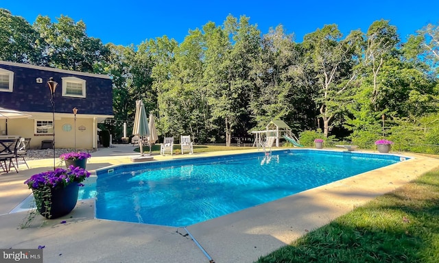 pool with playground community and a patio