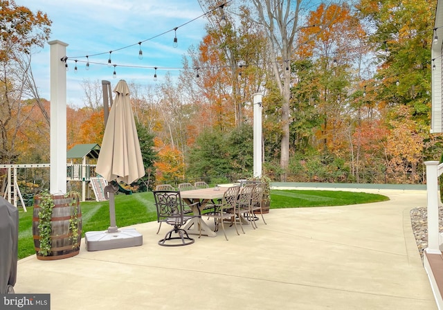 view of patio with outdoor dining area and playground community