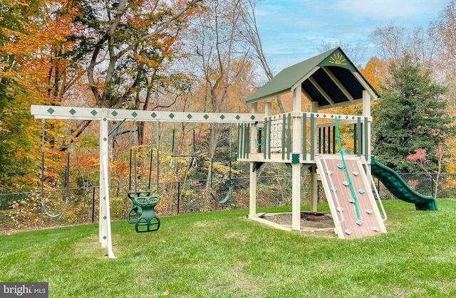 view of playground with a lawn and fence