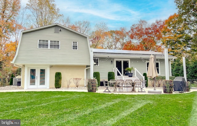 back of property featuring solar panels, a yard, french doors, and a patio area