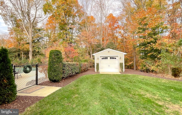 view of yard with an outbuilding, a detached garage, and fence