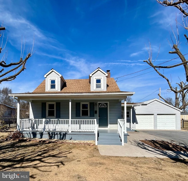 cape cod home with covered porch, a shingled roof, an outdoor structure, and a garage