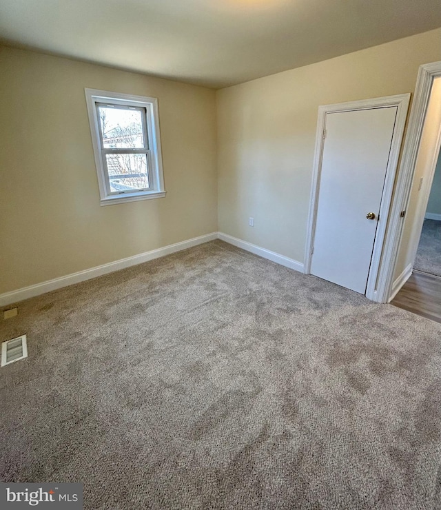 unfurnished bedroom featuring carpet, visible vents, and baseboards