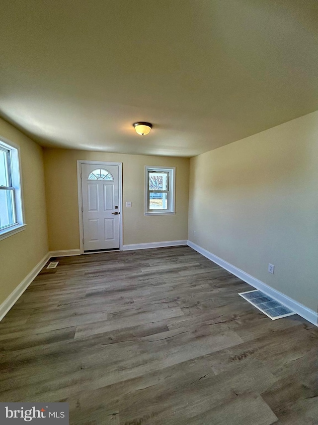 foyer featuring visible vents, baseboards, and wood finished floors