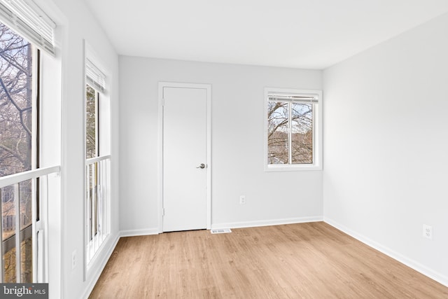 unfurnished bedroom with light wood-style floors, visible vents, and baseboards