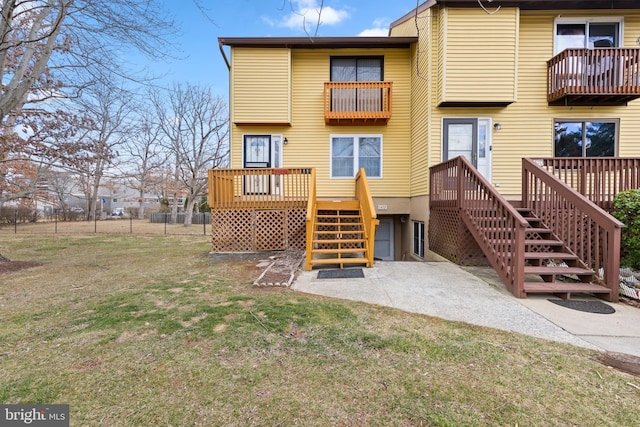 back of house featuring a yard, stairway, and fence