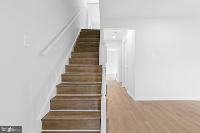 stairway with baseboards and wood finished floors