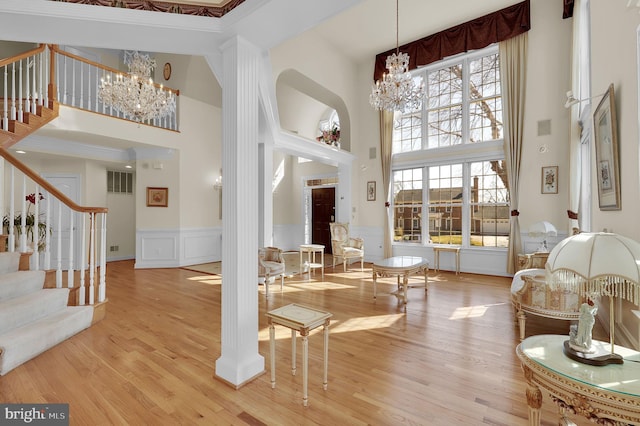 foyer entrance with a wealth of natural light, stairway, and a chandelier