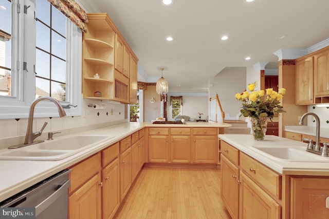 kitchen with light brown cabinetry, ornamental molding, dishwasher, and a sink