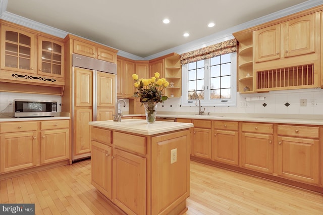 kitchen featuring a sink, a center island with sink, light brown cabinets, and open shelves