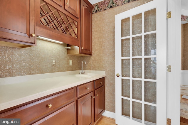 kitchen featuring a sink, brown cabinets, and light countertops