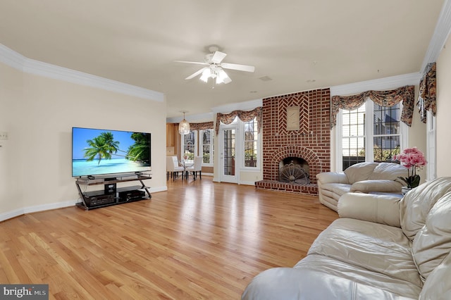 living area with plenty of natural light, a fireplace, light wood-type flooring, and ornamental molding