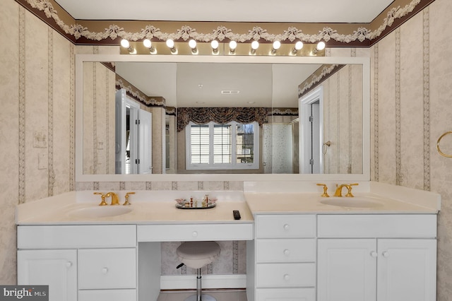 full bath with double vanity, visible vents, wallpapered walls, and a sink