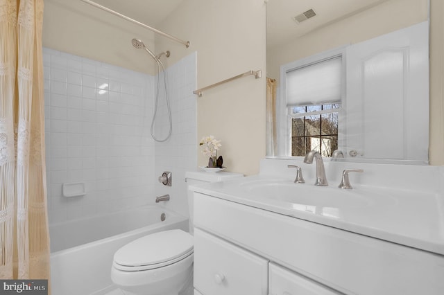 bathroom featuring visible vents, vanity, toilet, and shower / bath combo with shower curtain