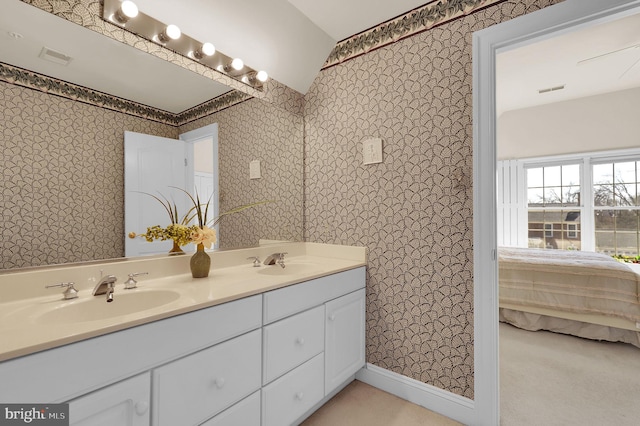 ensuite bathroom featuring wallpapered walls, double vanity, ensuite bathroom, and a sink