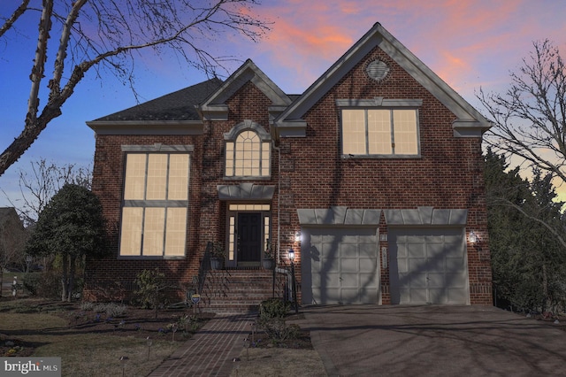 traditional-style home with concrete driveway, a garage, and brick siding