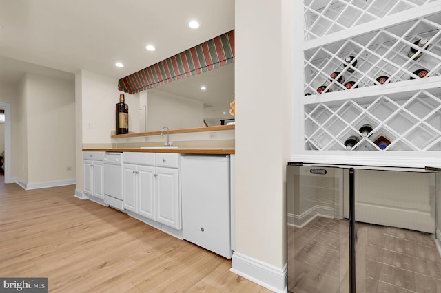 wine area featuring indoor wet bar, light wood-style flooring, recessed lighting, and a sink