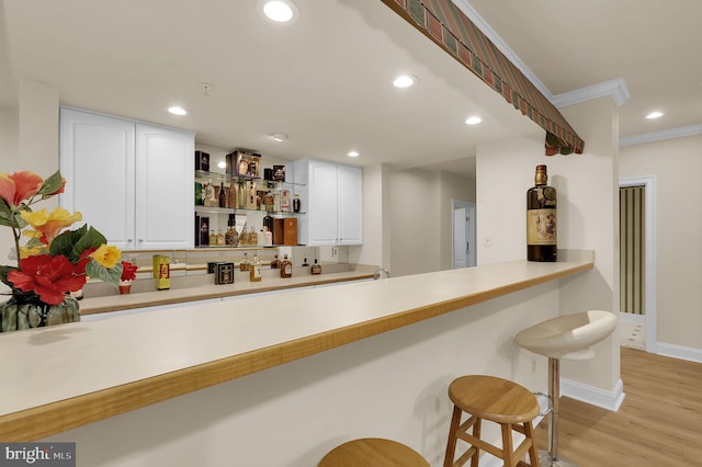 kitchen featuring light countertops, a kitchen bar, recessed lighting, light wood-style floors, and open shelves