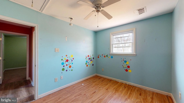 interior space featuring light wood-style flooring, attic access, visible vents, and baseboards