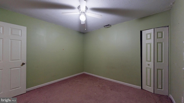 carpeted empty room featuring baseboards, visible vents, and a ceiling fan