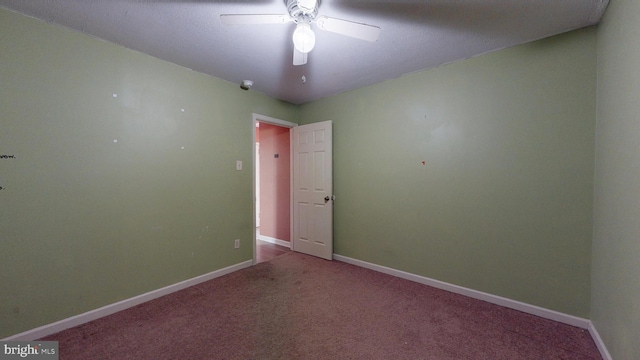 carpeted empty room with ceiling fan and baseboards