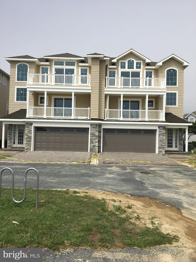 view of front of property with a garage, stone siding, and driveway