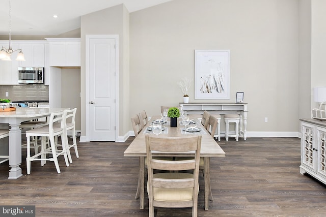 dining room with recessed lighting, dark wood finished floors, baseboards, and an inviting chandelier