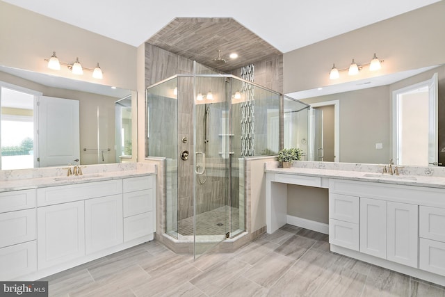 full bath featuring two vanities, a sink, and a shower stall