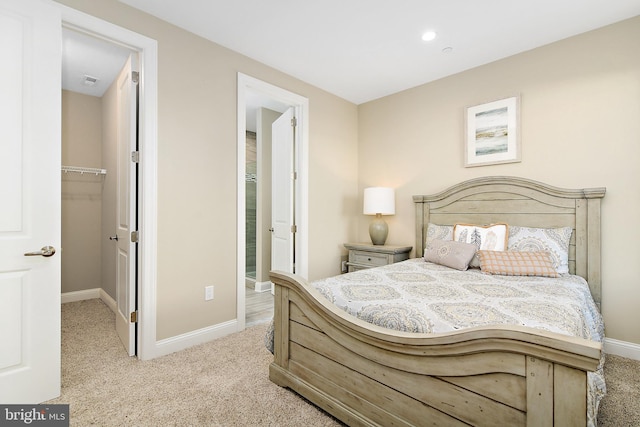 carpeted bedroom featuring a spacious closet and baseboards