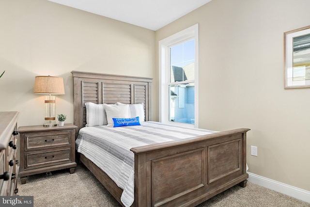 bedroom with light carpet and baseboards