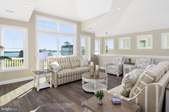 living area with visible vents, dark wood-type flooring, and a wealth of natural light