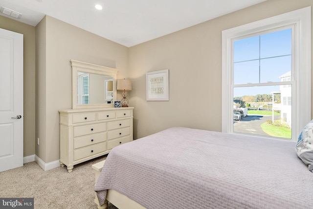 bedroom featuring baseboards, visible vents, and light colored carpet