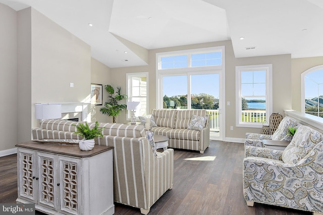 living area with dark wood-style floors, a fireplace, recessed lighting, visible vents, and baseboards