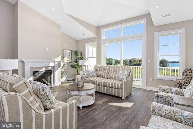 living area featuring dark wood-style floors, lofted ceiling, visible vents, a premium fireplace, and baseboards