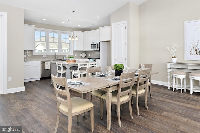 dining area featuring an inviting chandelier, baseboards, dark wood finished floors, and recessed lighting