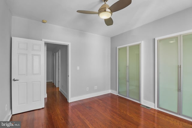 unfurnished bedroom featuring a ceiling fan, wood finished floors, visible vents, and baseboards