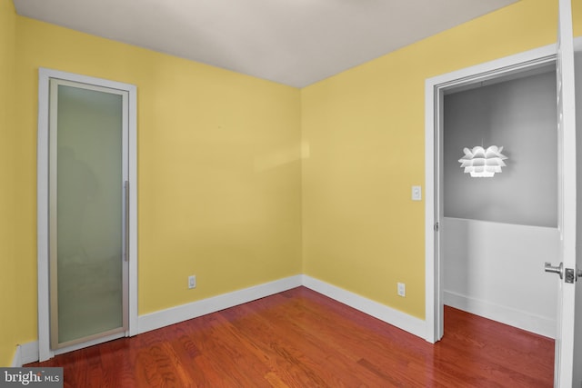 empty room with baseboards and wood finished floors