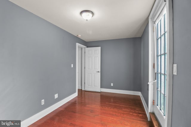 empty room with baseboards and wood finished floors