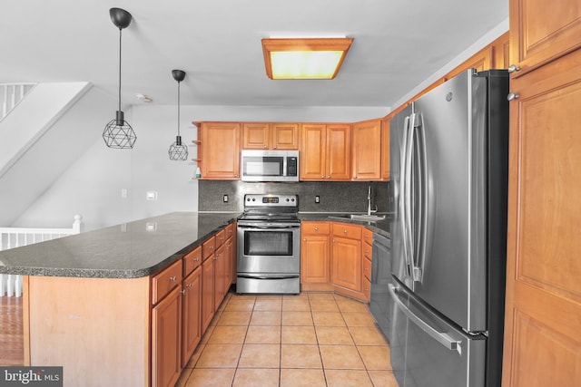 kitchen featuring light tile patterned flooring, a peninsula, a sink, appliances with stainless steel finishes, and decorative backsplash